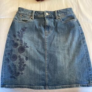 Denim jean skirt with floral embroidery.